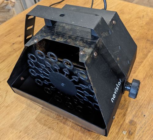 Vue trois-quart face de la machine, cuve vide, on aperçoit la roue à l’intérieur