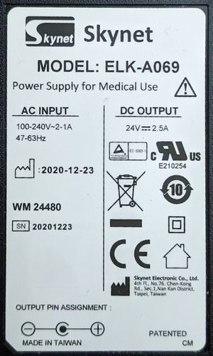 Etiquette sous l’adapateur secteur, indiquant « Skynet MODEL: ELK-A069 AC INPUT 100-240V-2-1A DC OUTPUT 24V 2.5A »