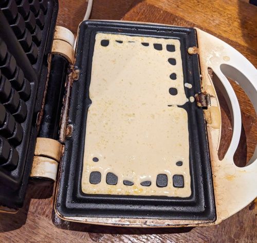 Louche de pâte à gaufre sucrée qui coule dans les rainures