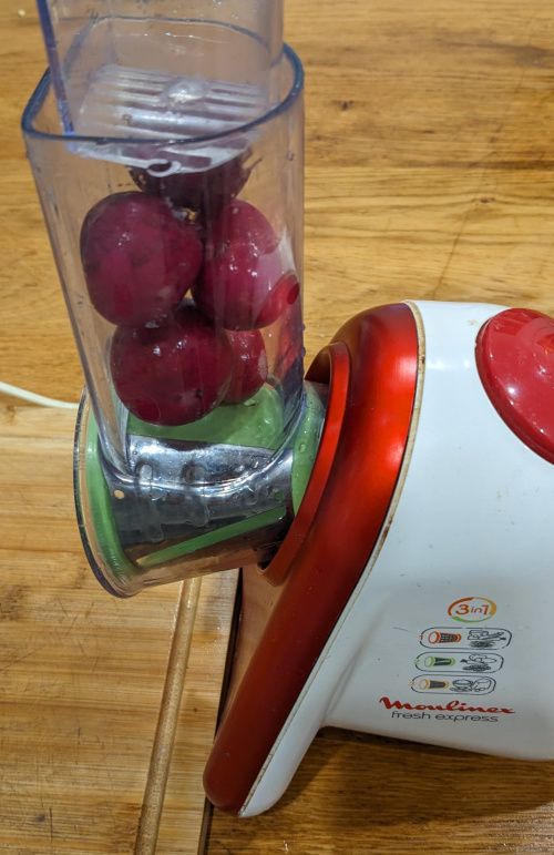 5 radis dans la goulotte du Fresh Express, prêts à être découpés, avec le cône vert visible