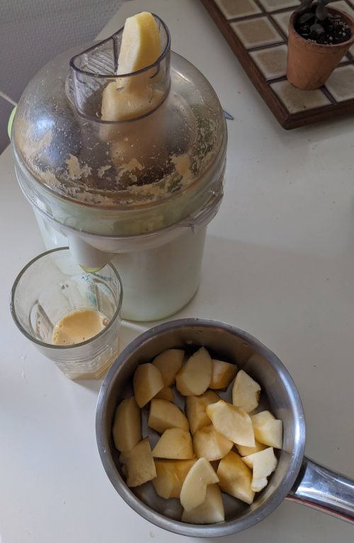 Vue de dessus&nbsp;: un morceau de pomme dans la cheminée, du jus dans le verre, et le reste des pommes dans la casserole