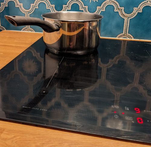 La casserole sans couvercle sur la plaque à induction, réglée au maximum
