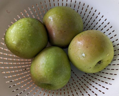 4 pommes lavées dans une passoire