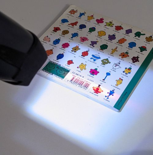 Le lecteur en train de scanner un code-barres ISBN sur un livre pour enfants.