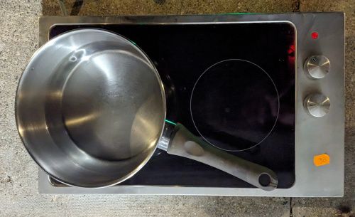 La plaque vitro-céramique IKEA à deux foyers, avec la casserole sur le foyer de gauche