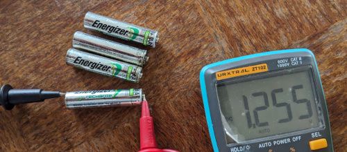 Multimètre affichant 1,255 V pour les piles AAA avant la charge