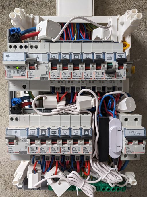 Tableau électrique ouvert, où on voit un module Shelly 3EM, un module noir contenant 2 Shelly EM, et 7 pinces ampèremétriques