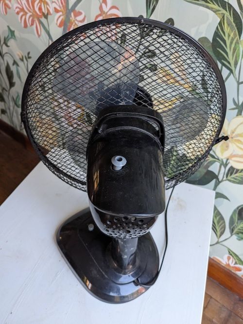 Photo de l’arrière du ventilateur montrant la tirette permettant d’activer ou désactiver l’oscillation horizontale de la tête du ventilateur