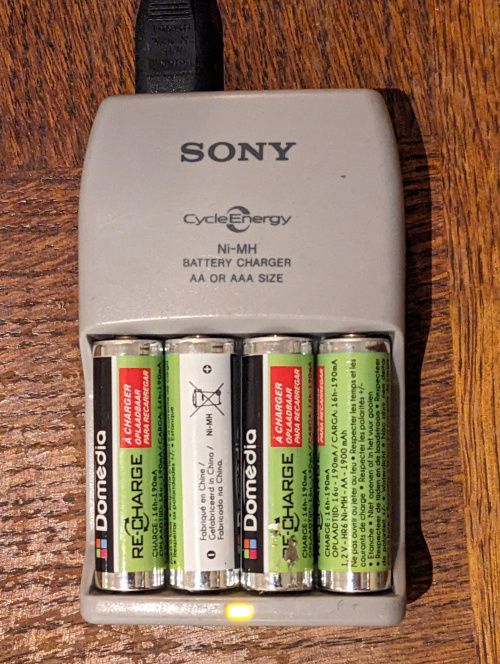 4 piles AA Domedia Re:Charge en cours de charge, LED témoin allumée