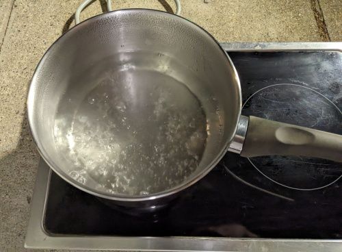 L’eau bout dans la casserole sur la plaque vitro-céramique