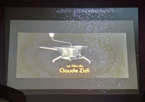 Le générique de début du film projeté sur le mur, avec de nombreux points blancs