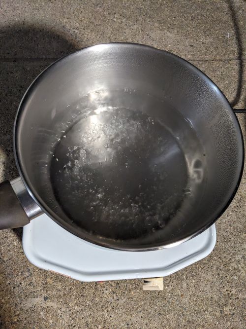 L’eau bout franchement dans la casserole sur la plaque en fonte